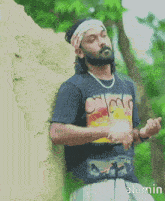a man with a beard wearing a headband and a t-shirt that says calm on it