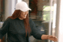 a woman wearing a white hat is standing in front of a refrigerator .
