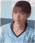 a woman in a blue scrub top is sitting on a couch .