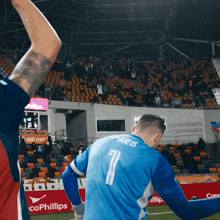 a soccer player wearing a blue jersey with the number 74 on the back