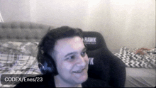 a man wearing headphones and a hawk gaming chair