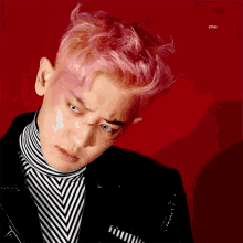 a man with pink hair is wearing a striped shirt