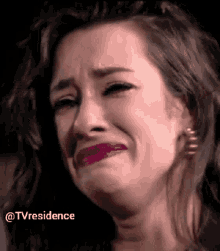 a close up of a woman 's face with a tear running down her cheek .