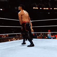 a man in a wrestling ring with a bottle of primus on the floor