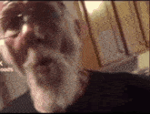 a man with glasses and a beard looks at the camera with the words goods below him