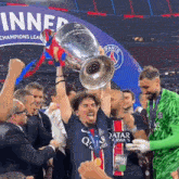 a man in a qatar jersey holds a trophy