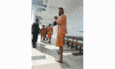 a group of men are walking down a hallway and one of them is wearing a shirt that says ' prison ' on it