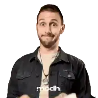 a man wearing a black jacket and a necklace with the word mcdh on it