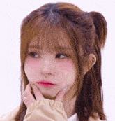 a close up of a girl making a funny face with her hand on her chin
