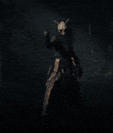 a person in a dark forest with a mask on