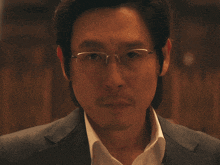 a man with glasses and a beard is looking at the camera
