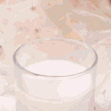 a plate of cookies with hearts on them sits next to a glass of milk