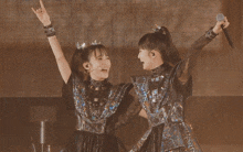 a couple of girls with their arms in the air