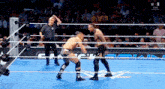 two wrestlers in a wrestling ring with a referee and a sign that says ' n live ' on it