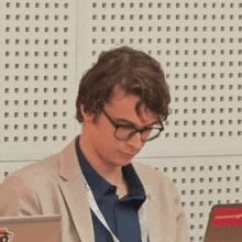 a man wearing glasses has a lanyard around his neck that says ' nvc ' on it