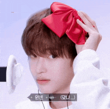 a person wearing a red bow on their head with korean writing on the bottom right
