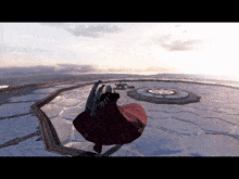 a person in a red coat with wings is standing on a snow covered surface