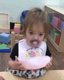 a little girl wearing a bib that says orange you cute on it
