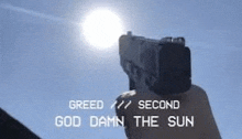 a person is holding a gun in front of the sun and says greed second god damn the sun .