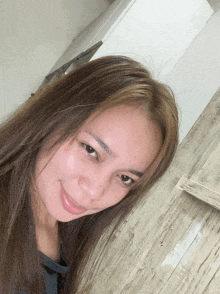 a woman with long hair is smiling for the camera