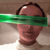 a woman is holding a green object over her eye