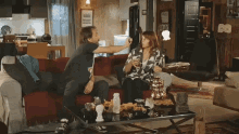 a man and a woman are sitting on a couch in a living room with a coffee table