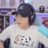 a woman wearing headphones and a cow shirt says no you do it