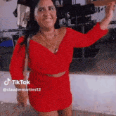 a woman in a red dress and shorts is dancing on a stage .