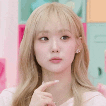 a woman with blonde hair making a face with her hand