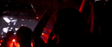 a crowd of people are dancing in a dark room at a concert .