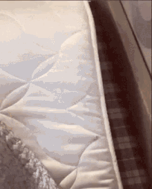 a white mattress is laying on a bed next to a plaid pillow
