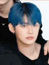 a man with blue hair is sitting next to another man .