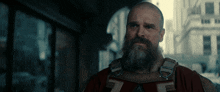 a man with a beard is wearing a red vest with a z on it