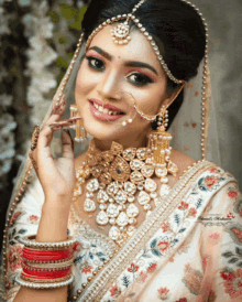 a bride wearing a veil and a necklace with the name daniel written on the bottom left