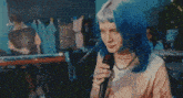 a naked woman with blue hair stands in front of a blue wall