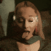 a woman wearing glasses is sticking her tongue out
