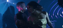 a woman in a green dress dancing in a dark room