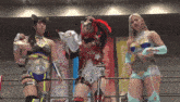three women are standing in a wrestling ring with one wearing a belt that says t23