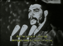 a black and white photo of a man speaking into microphones with the words and the statue of lumumba destroyed today but rebuilt tomorrow