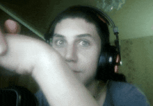 a woman wearing headphones is making a face