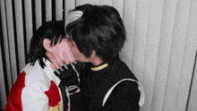 two people kissing with one wearing a jacket that says reebok on it