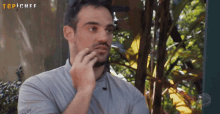 a man with a beard is talking on a cell phone with the words top chef behind him