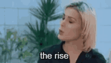 a woman is saying the rise in front of a plant
