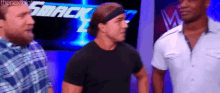 a group of men are standing next to each other in front of a sign that says smackdown .