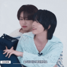 a couple of boys are hugging each other and one of them is wearing a blue shirt that says chimen