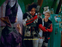 a woman in a purple hat says " toy squeaking " next to a man in a red jacket
