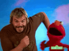 a man and elmo from sesame street are posing for a picture