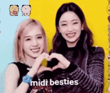two girls are making a heart shape with their hands and the words midi besties are on the bottom .