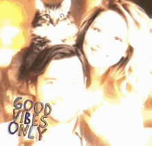 a man and a woman are posing for a picture with a cat sitting on their head .