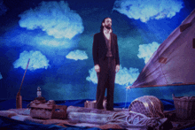 a man with a beard is standing on a raft in the ocean